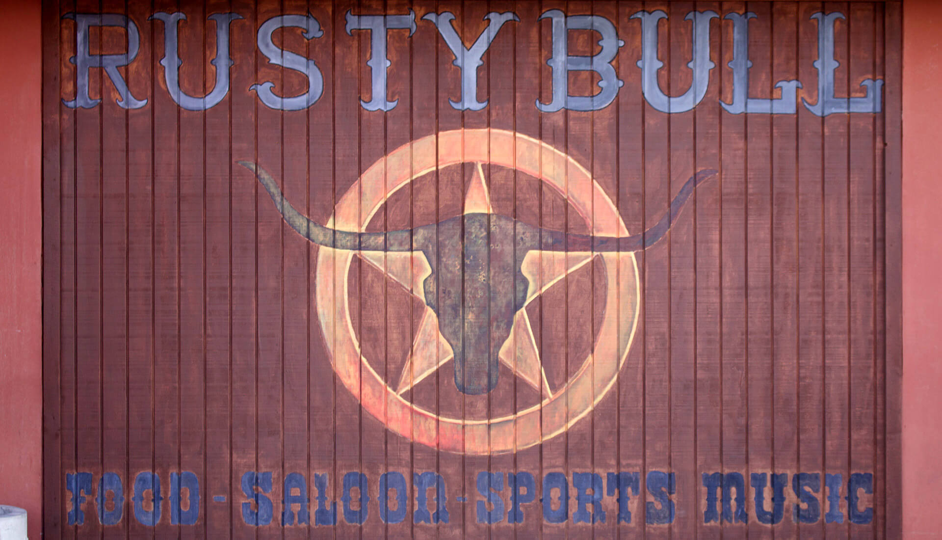 Rusty Bull Roadhouse Sign with the words Food, Saloon, Sports and Music 